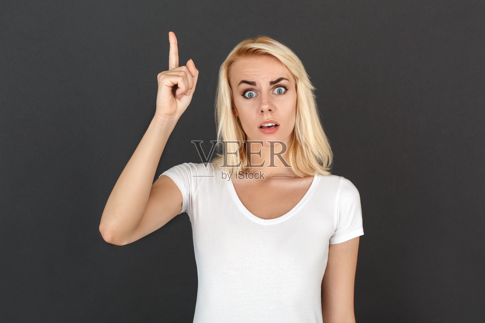 自由泳。孤立地站在黑墙上的女子指着上面的解决方案照片摄影图片