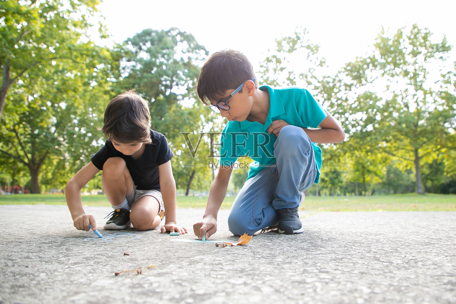 专注地坐在地上的男孩们照片摄影图片