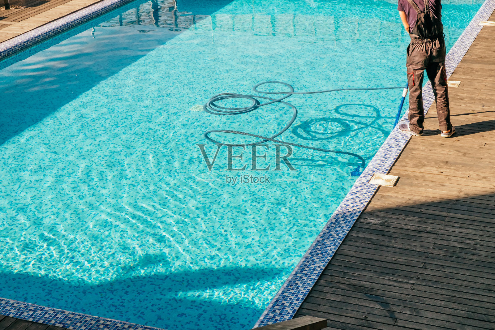 用真空设备清洁游泳池的人照片摄影图片