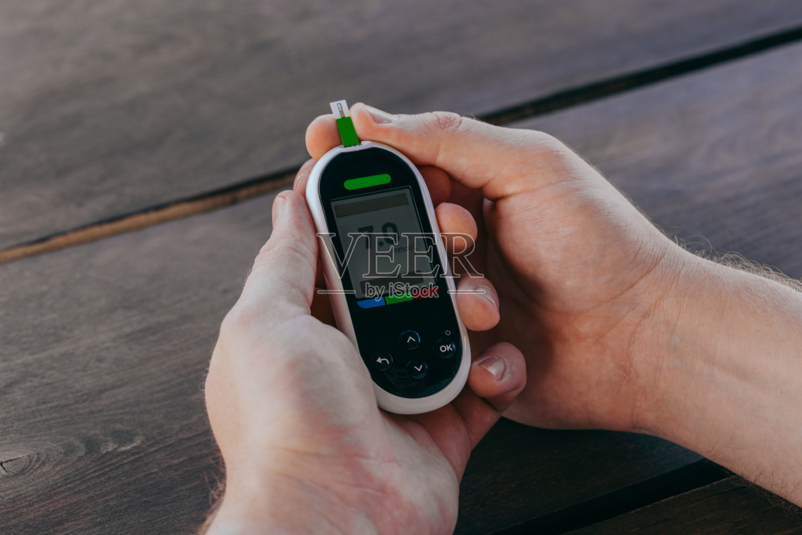 医学，糖尿病，血糖，保健和人们的概念-爱在家用血糖仪和测试条检查血糖。照片摄影图片