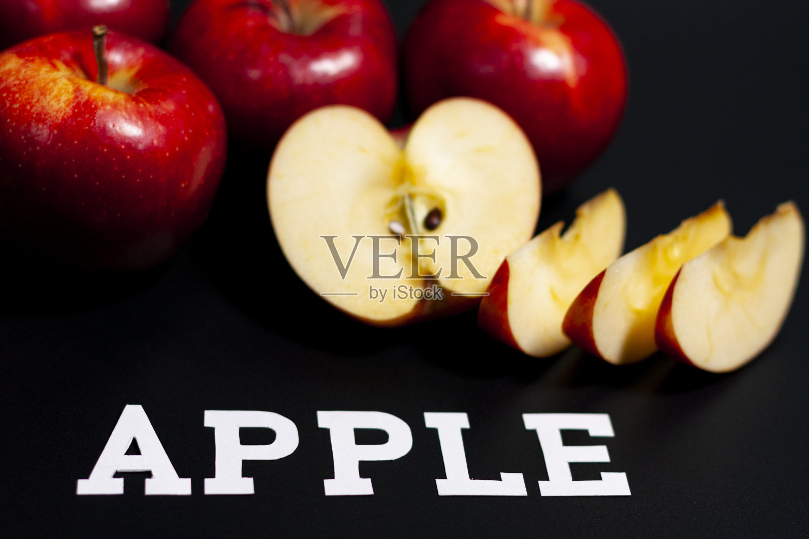 在屏幕中央是切片和半个红色多汁的苹果。特写镜头。照片摄影图片