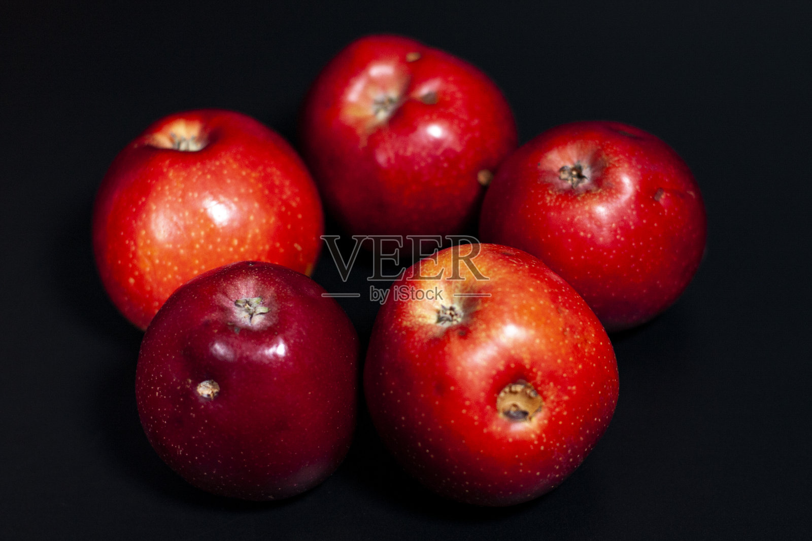 在屏幕中央放五个新鲜的红苹果。有些水果有缺陷。照片摄影图片
