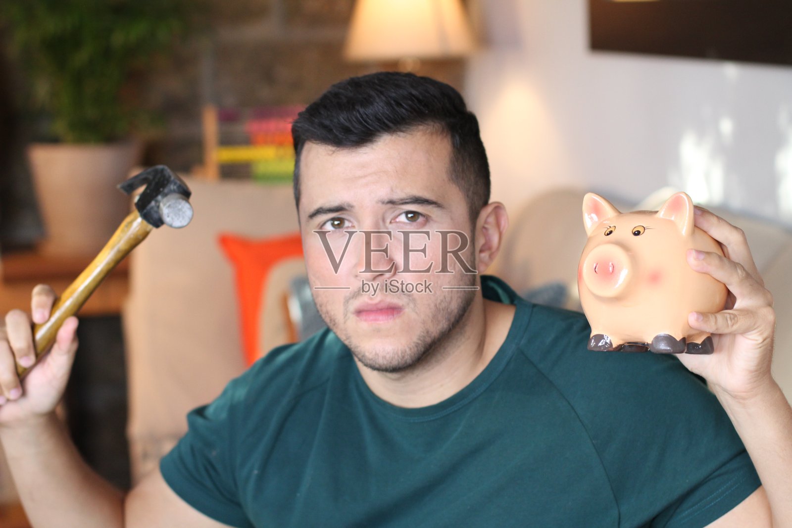 一个少数民族的年轻人正要打破存钱罐照片摄影图片