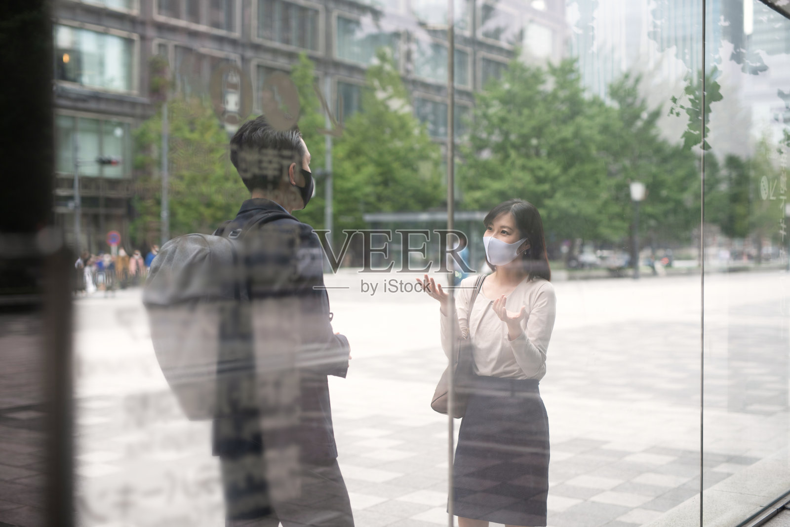 亚洲女商人和带面具的商人正在讨论照片摄影图片