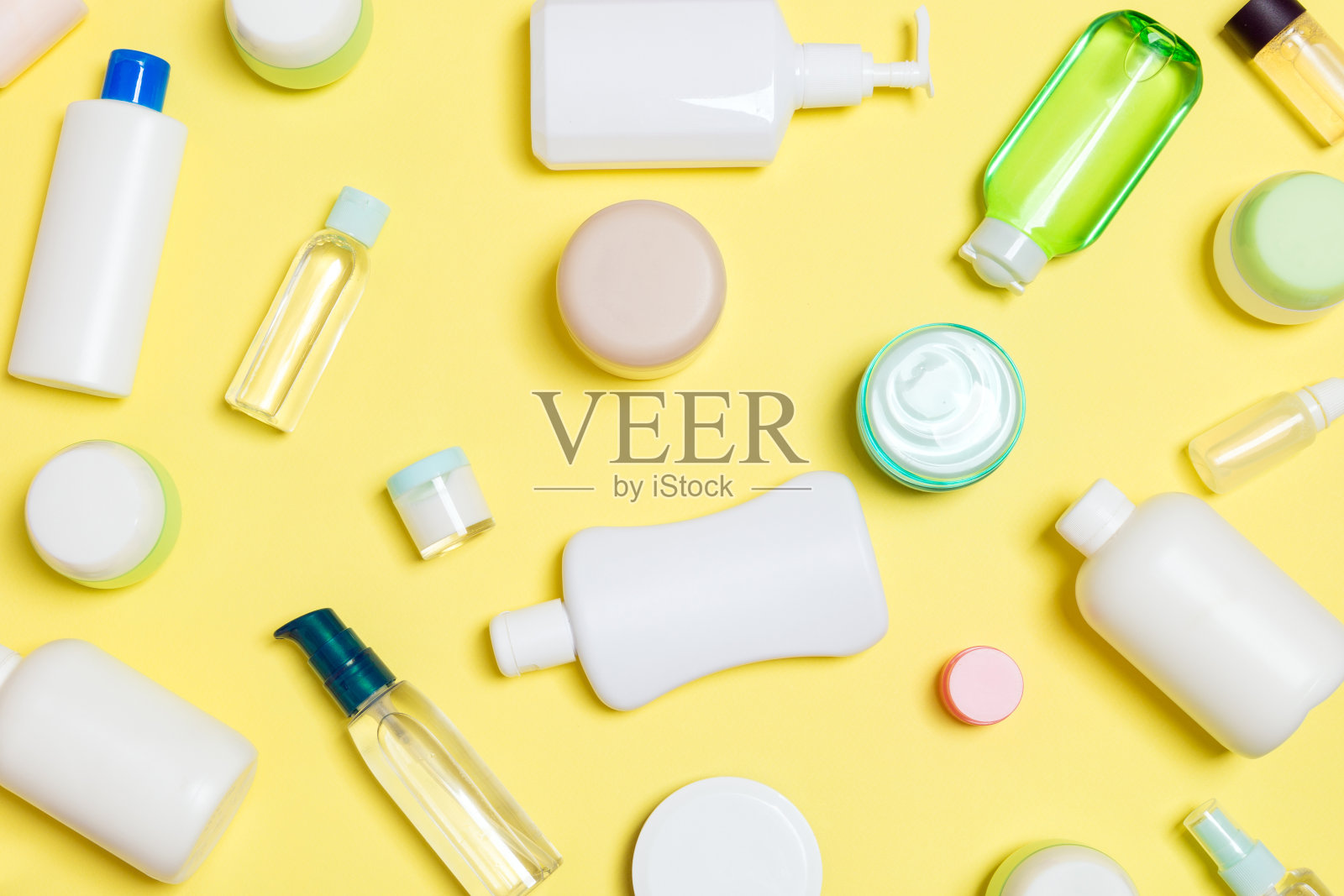 组塑料美体瓶平铺构图与化妆品在黄色的背景空白为您设计。一套白色化妆品容器，顶视图与复制空间照片摄影图片