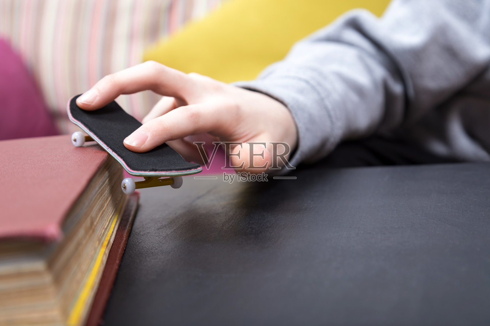 男孩正在玩手指滑板。近距离拍摄照片摄影图片