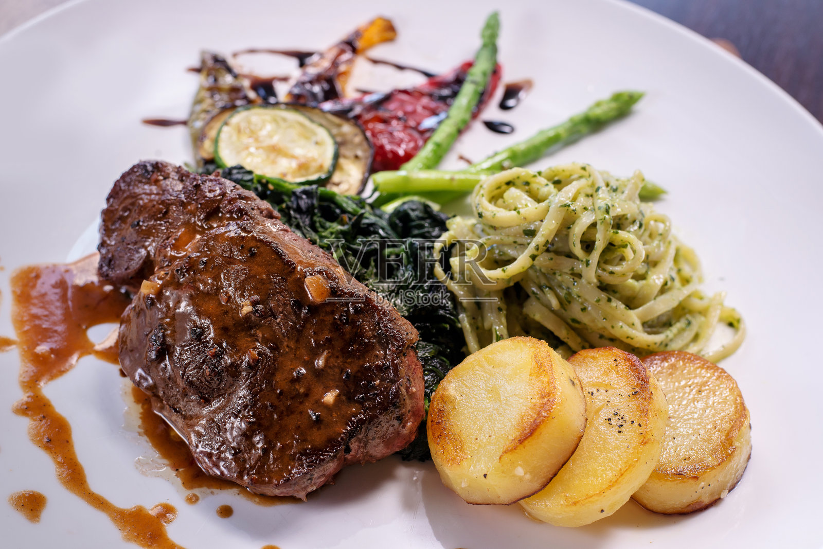 烤牛排配上几道配菜照片摄影图片