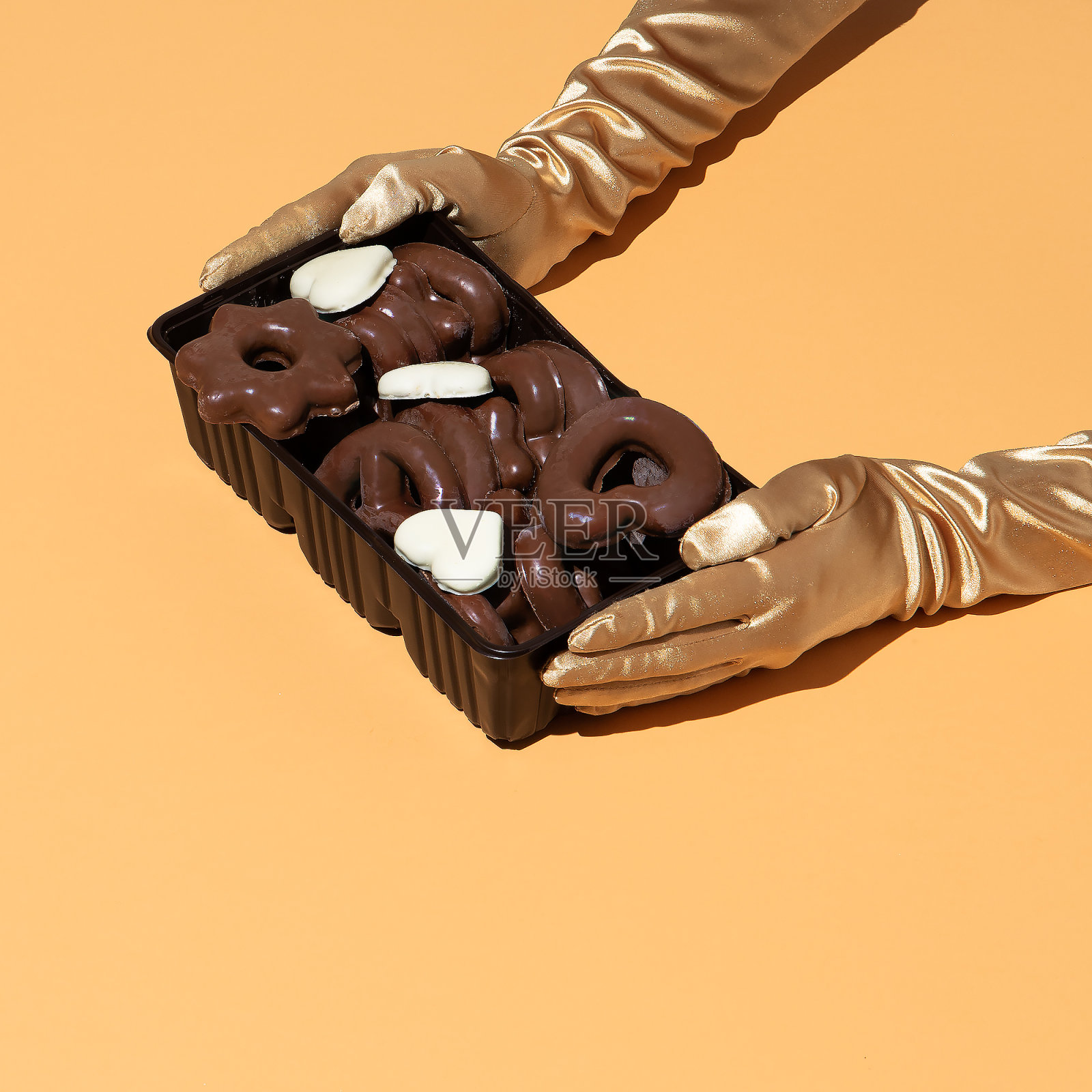 装在盒子里的巧克力饼干和手套。简约静物时尚食品概念。 巧克力上瘾的想法。节日冬季甜蜜的季节照片摄影图片