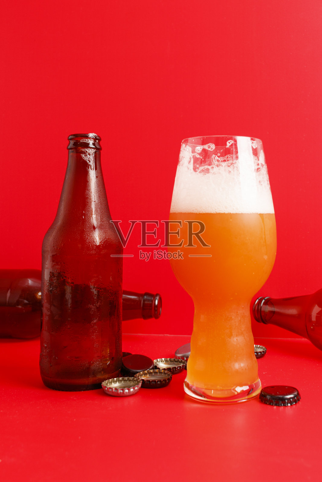 IPA啤酒杯和各种带有红色背景的瓶子照片摄影图片