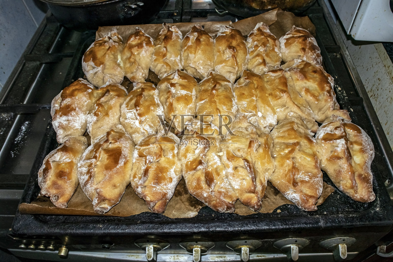 烤盘上刚出炉的热腾腾的玫瑰色馅饼照片摄影图片