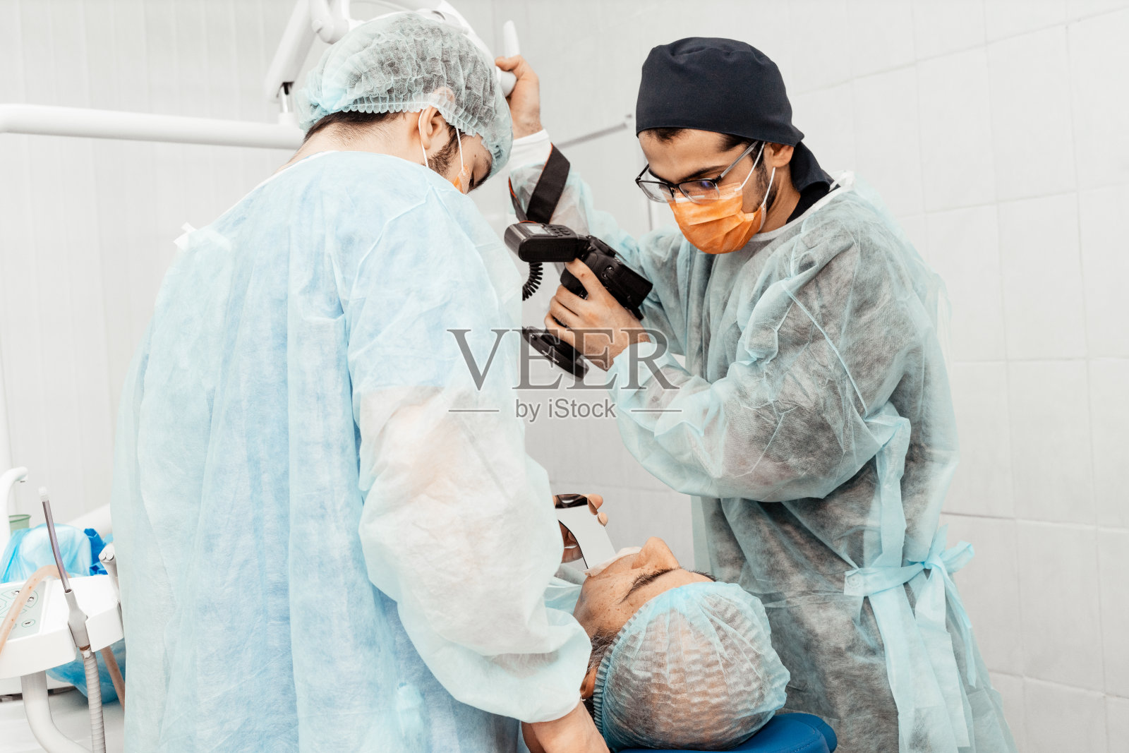 牙医会做手术，植入。实际操作。拔牙,植入物。牙医的专业制服和设备。医疗设备doctorâ的工作场所。牙科照片摄影图片