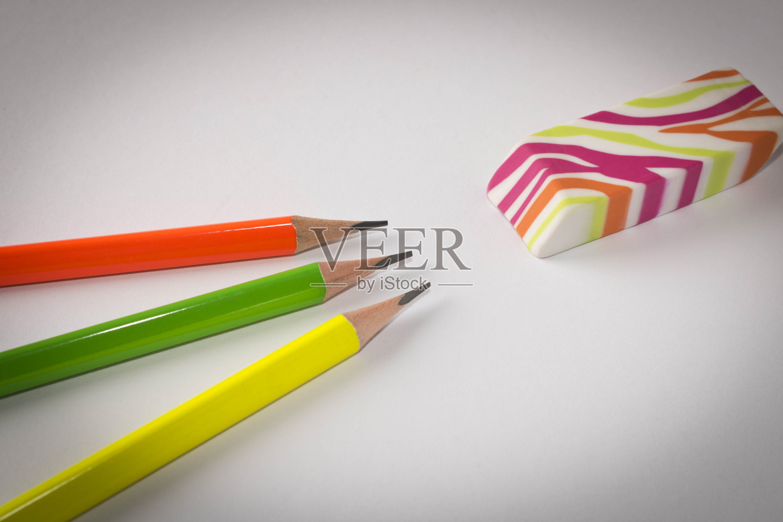 彩色的橡皮和简单的铅笔在一个明亮的背景。关闭了。有选择性的重点。照片摄影图片