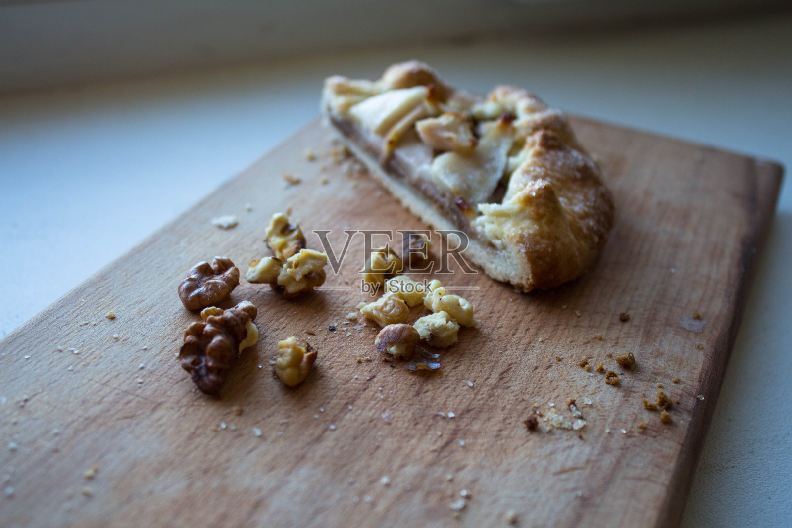 一块有苹果和坚果的派放在一块木板上照片摄影图片