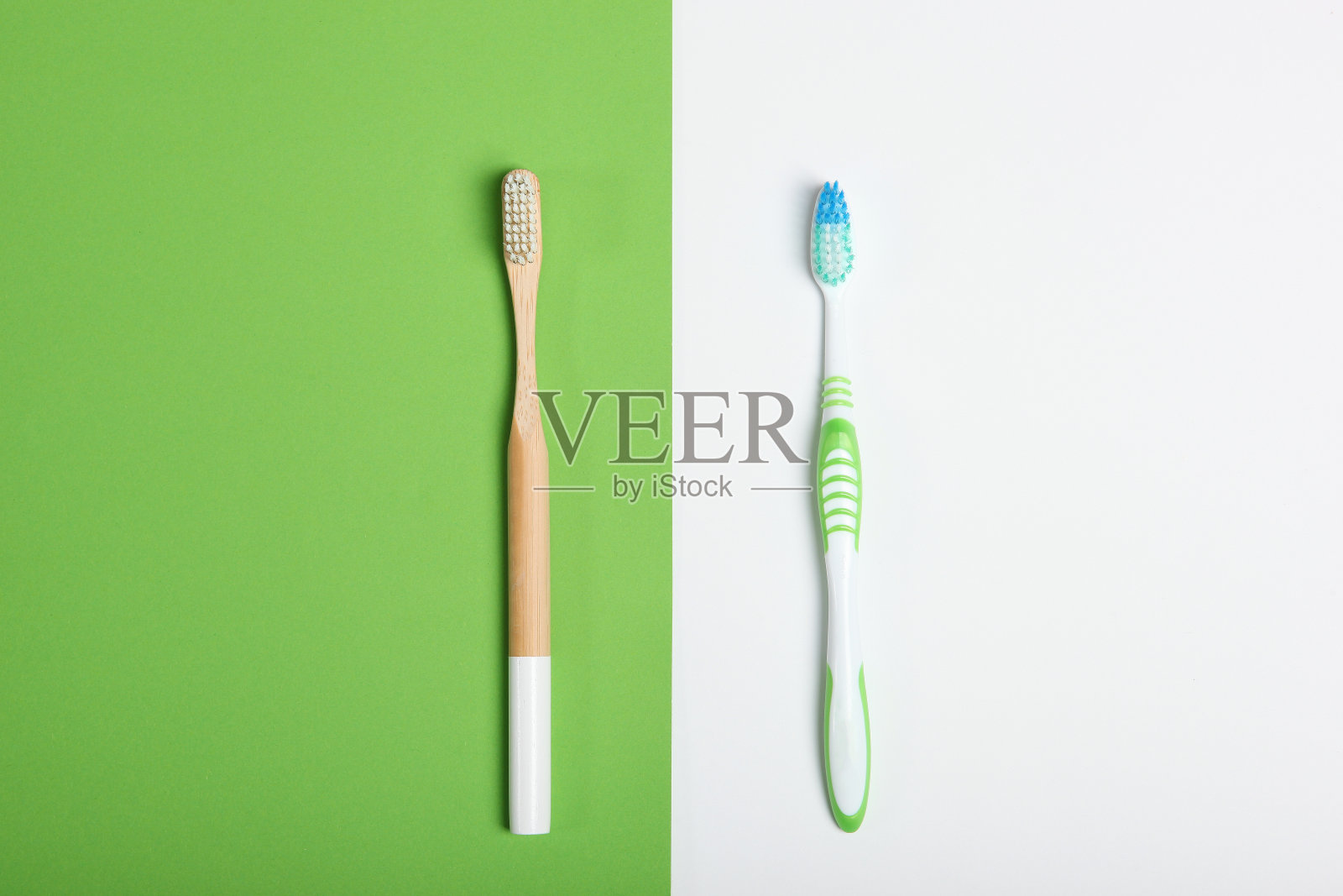 天然竹牙刷和塑料上的彩色背景俯视图。照片摄影图片