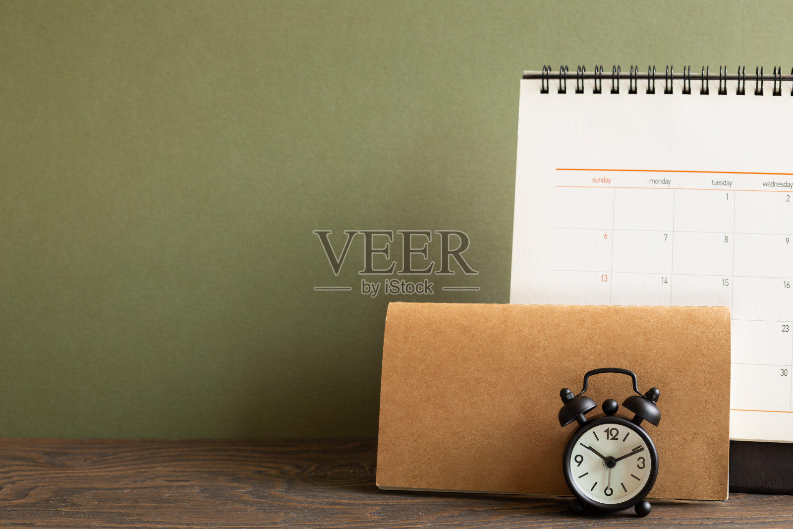桌上有卡其色背景的日历和闹钟。业务时间表和时间概念照片摄影图片