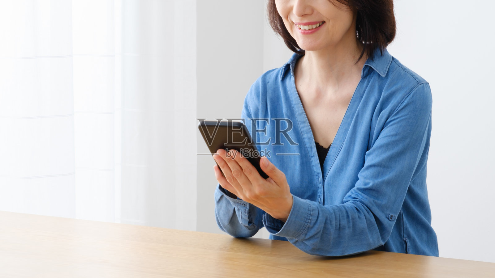 中亚妇女在客厅使用智能手机的肖像照片摄影图片