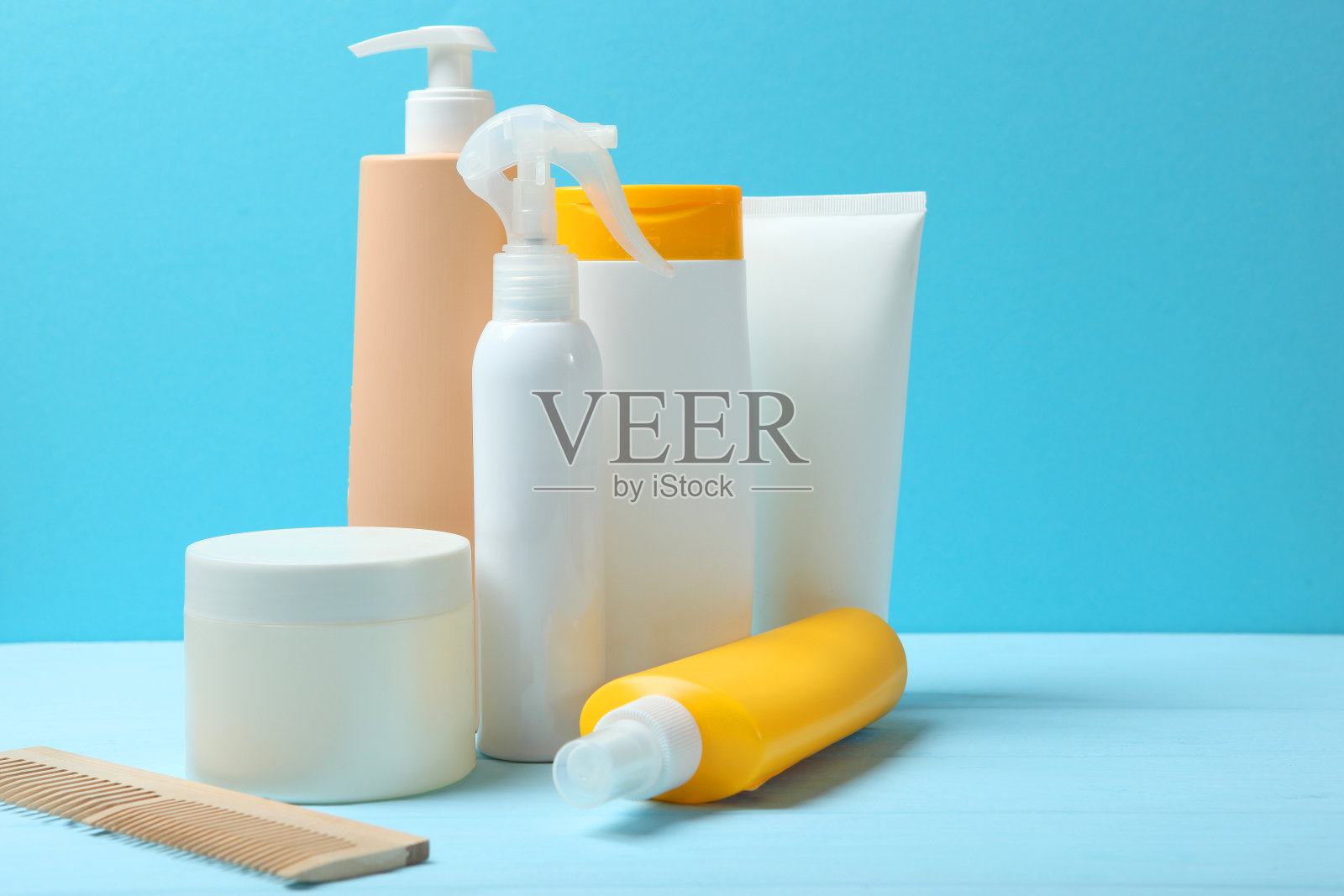 护发用品和梳子放在桌上。照片摄影图片