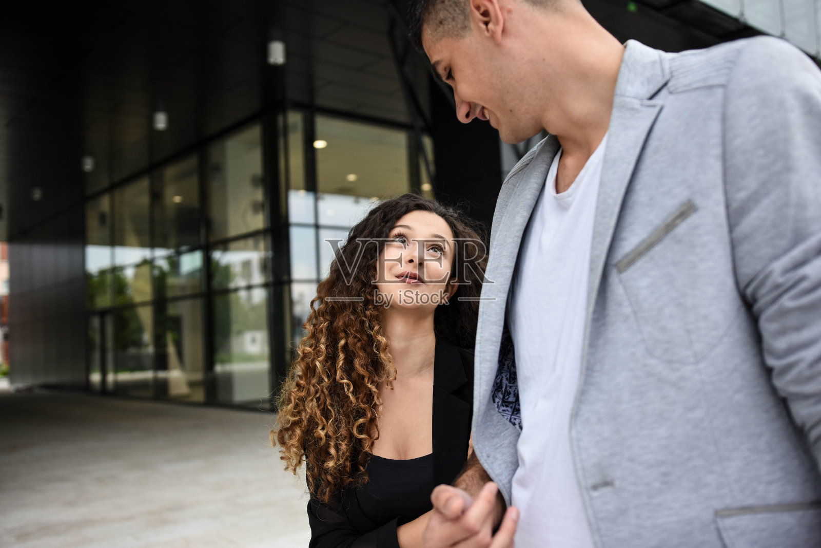 两个年轻的商人，同事在办公楼前面照片摄影图片