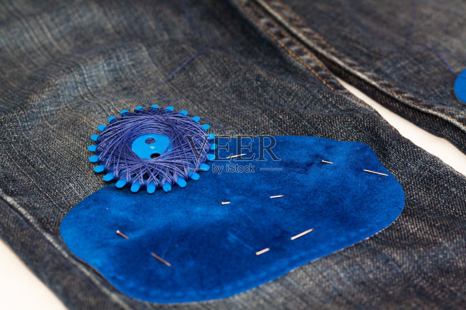 牛仔裤上的蓝色补丁准备好了照片摄影图片