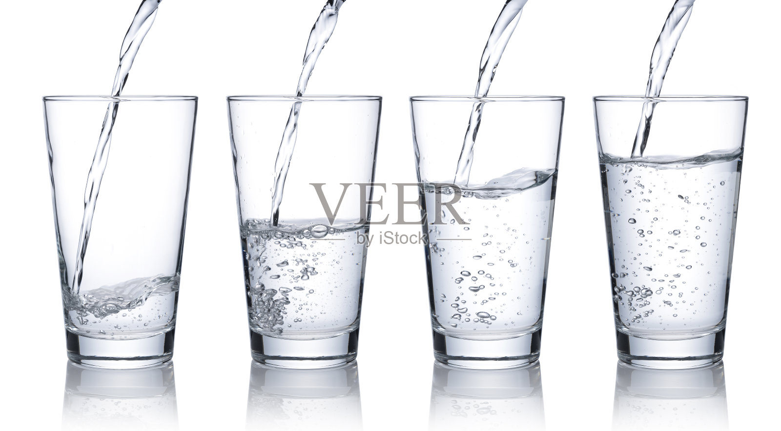 将水倒入一个白色背景的透明玻璃杯中。照片摄影图片