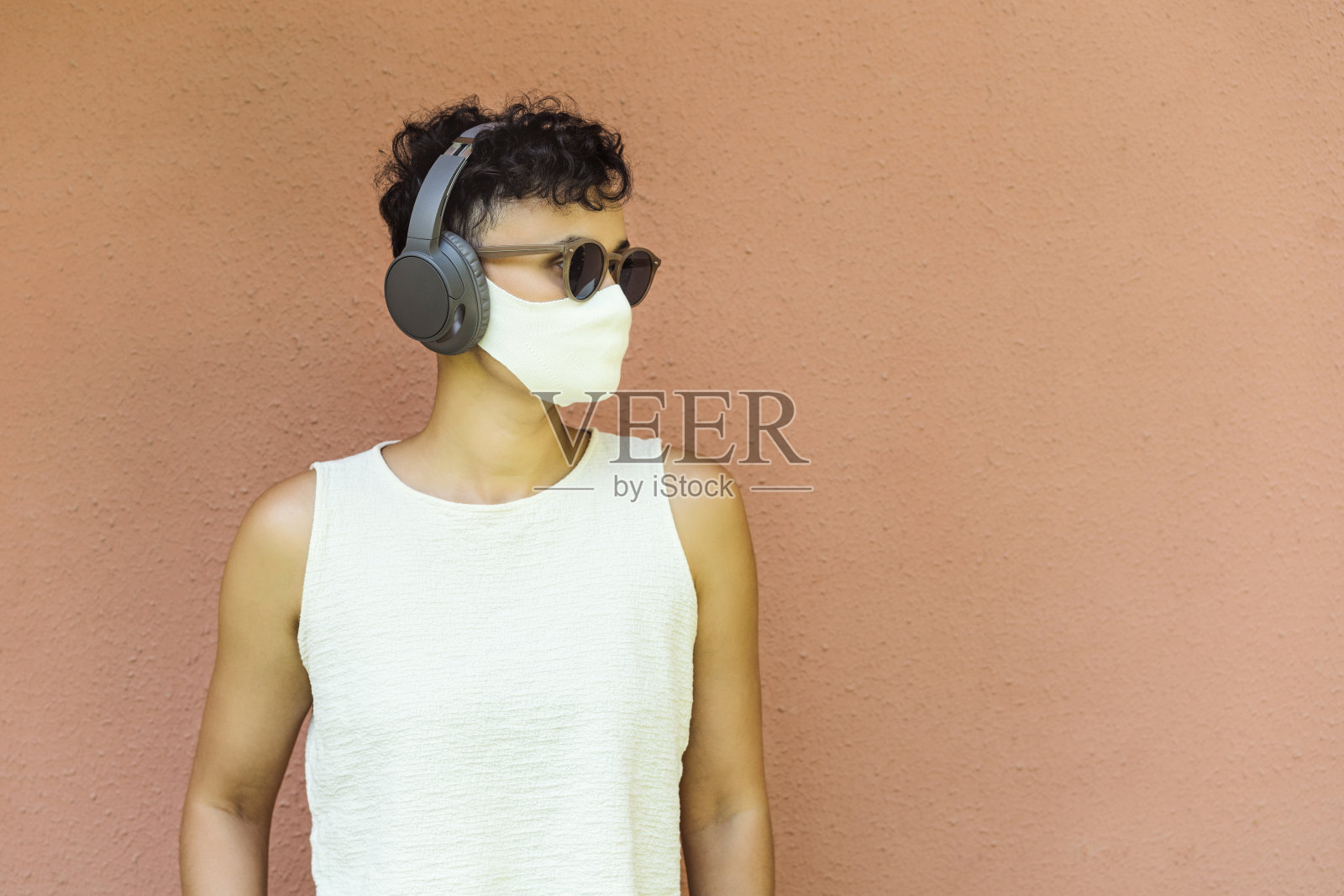 一个年轻女子的肖像戴着防护面具在橙色的墙壁前照片摄影图片