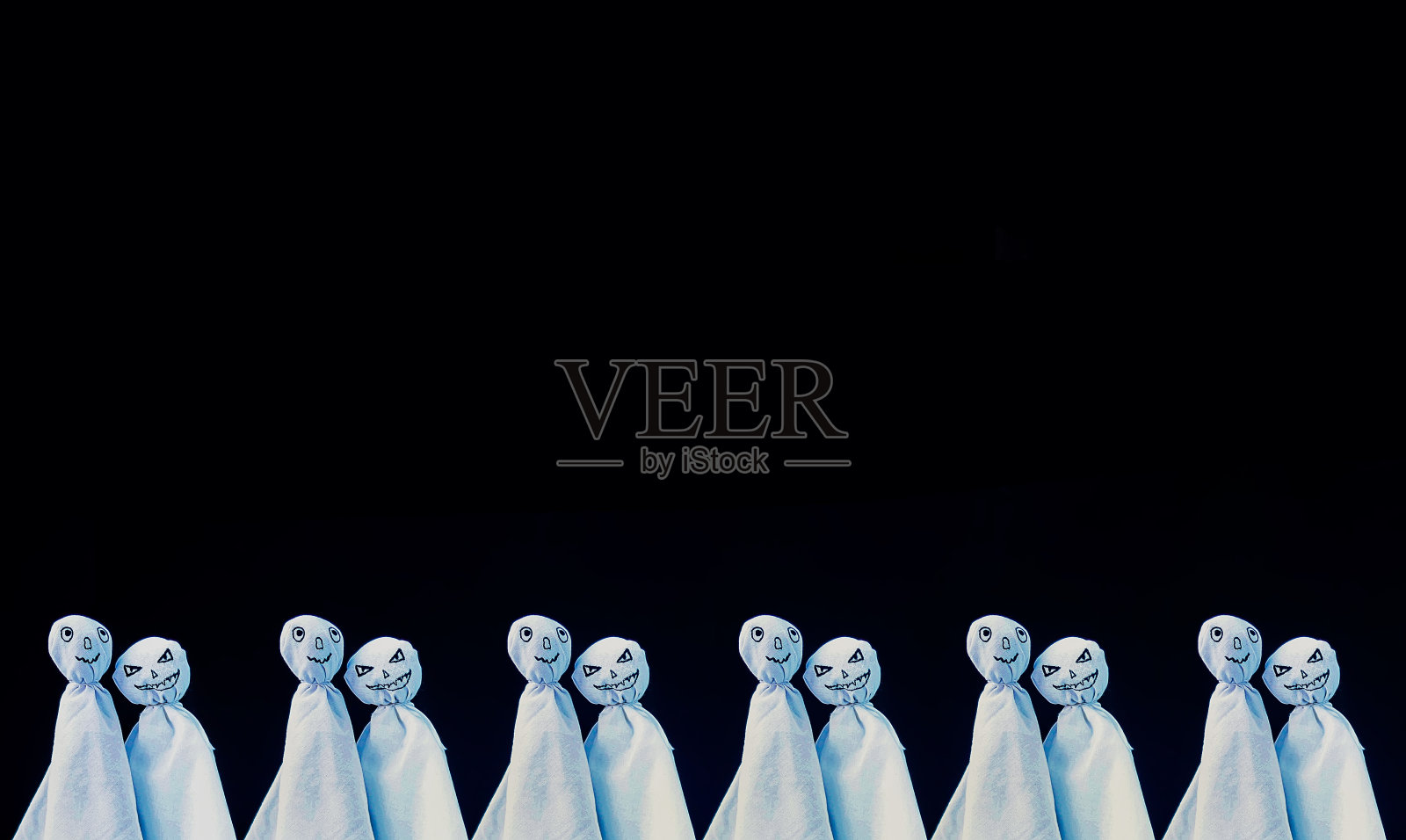 为万圣节装饰。黑色背景上的两个幽灵。手工装饰的派对。照片摄影图片