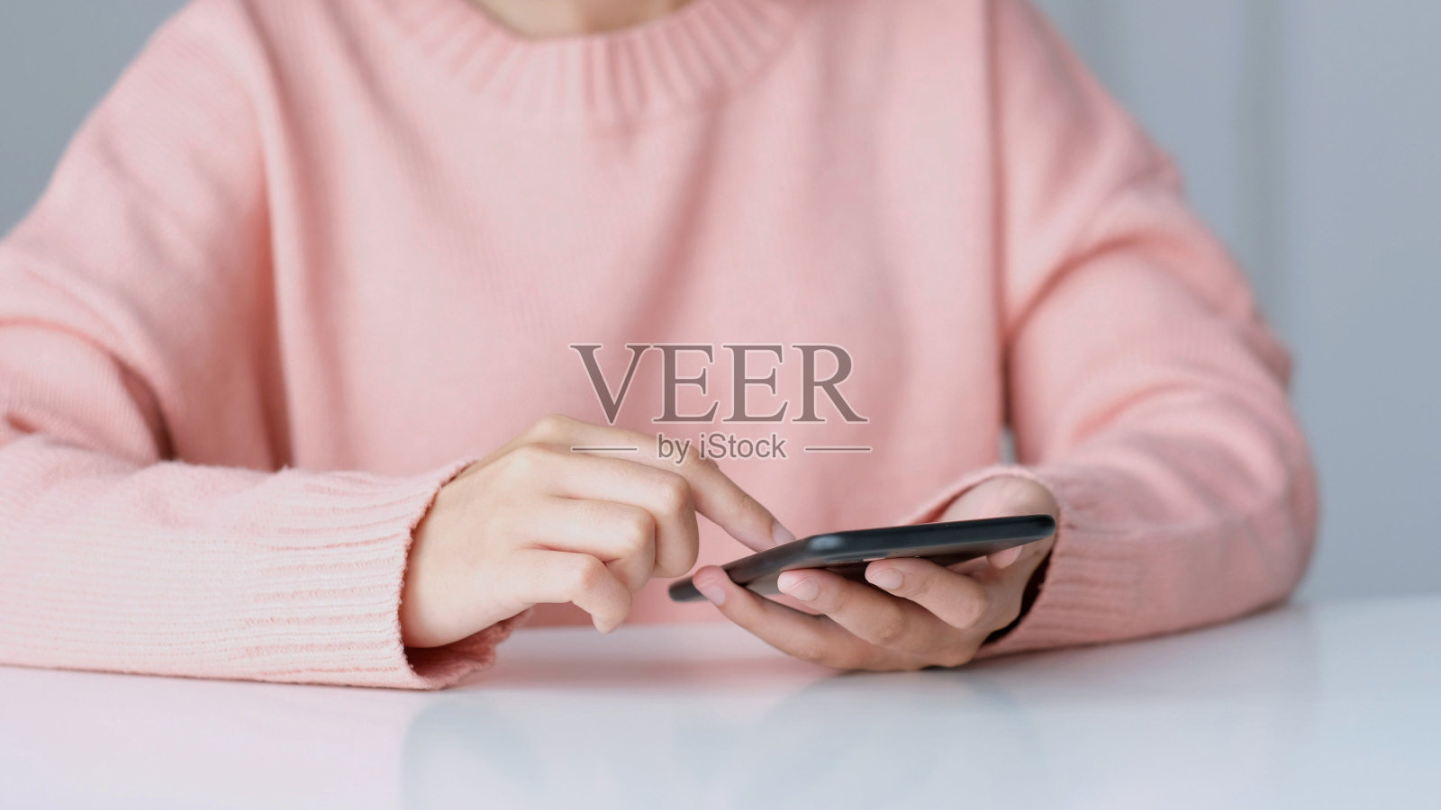 近距离的女人手在家里使用手机，人们在智能手机，技术生活方式，电子商务，在线商务，e学习，教育，物联网的概念照片摄影图片