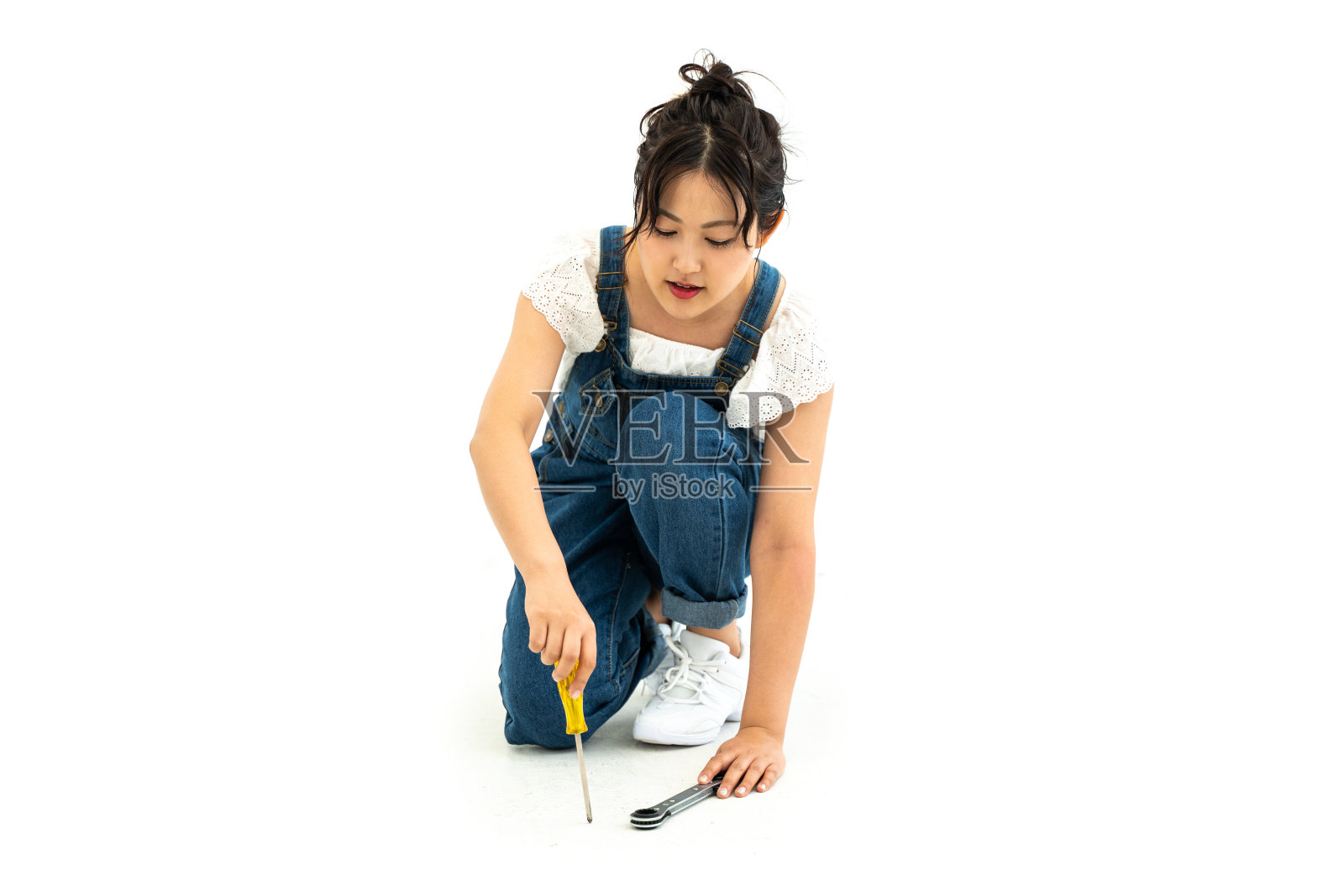 年轻女子，手拿棘轮扳手照片摄影图片