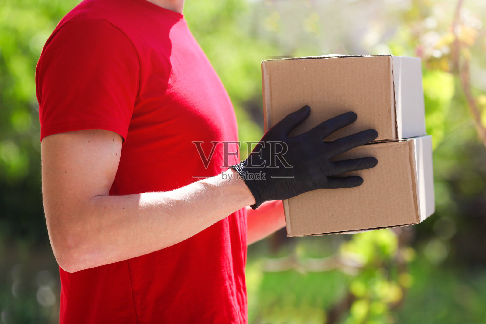 男人们正双手戴着黑色橡胶手套拿着棉箱，在户外。照片摄影图片