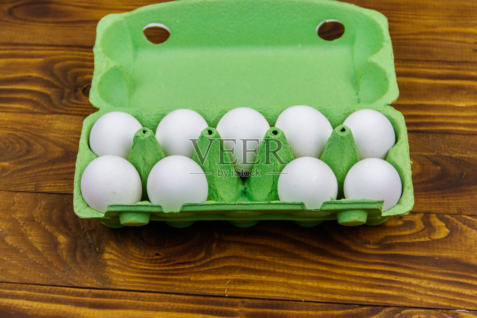 生鸡蛋放在纸板箱里，木桌上有空位照片摄影图片
