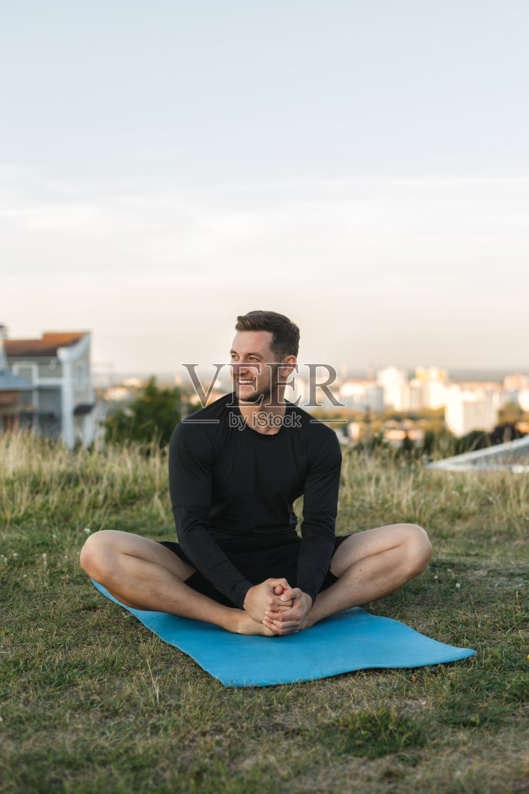 一个健康人在户外运动场上伸展身体的形象照片摄影图片