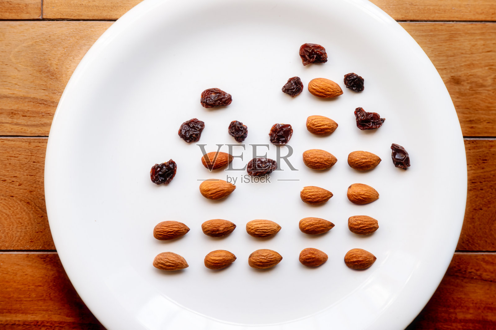 一个装有杏仁和葡萄干的盘子的俯视图，模拟一个条形和线形图照片摄影图片