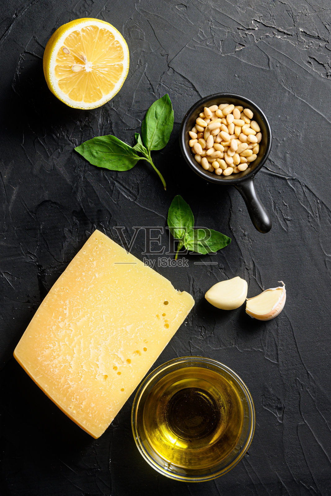 热诺维斯香蒜酱，以黑石为背景，加入帕玛森奶酪、罗勒叶、松子、橄榄油、大蒜和盐。传统的意大利美食。前视图。照片摄影图片