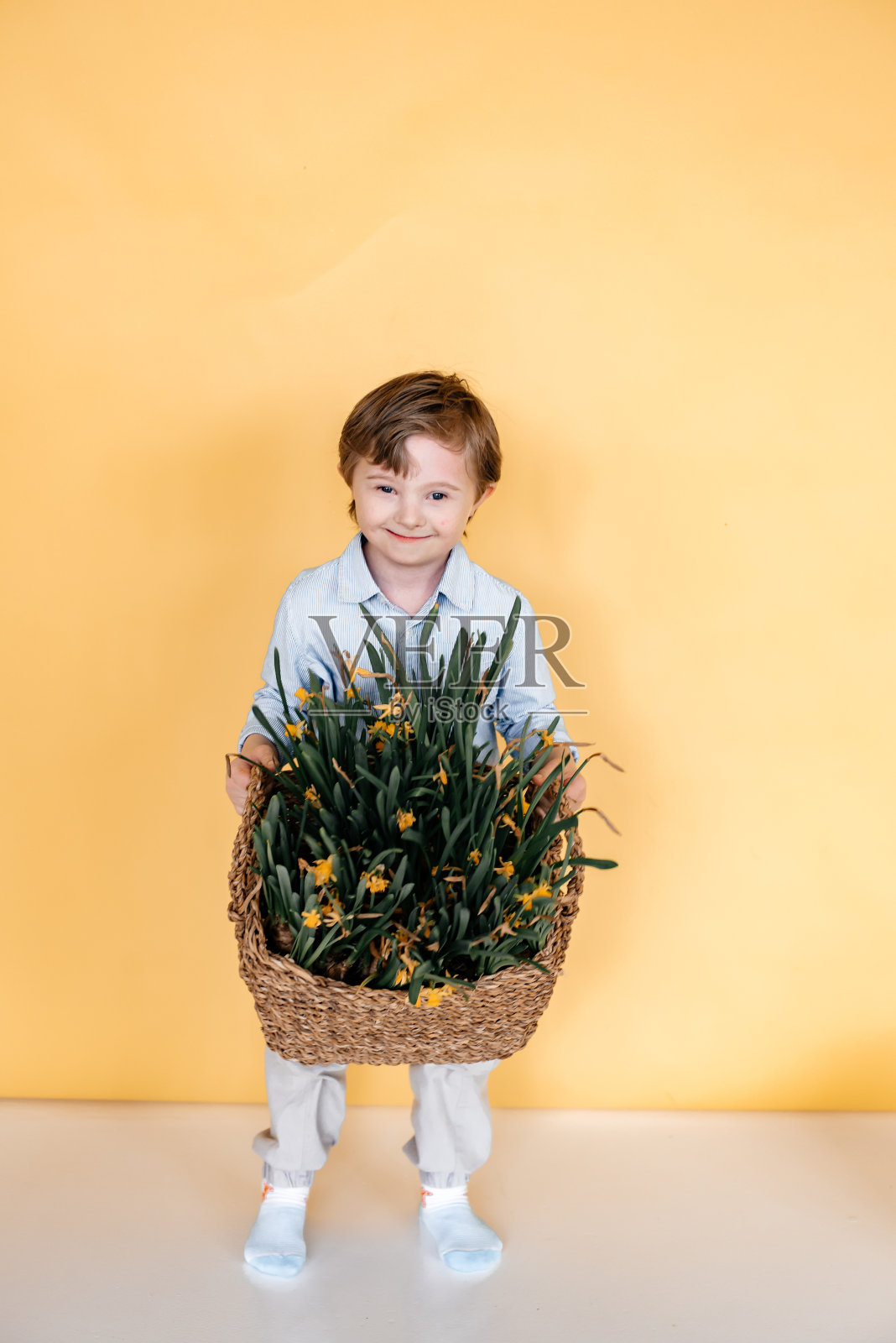 那孩子手里拿着一大束花。照片摄影图片