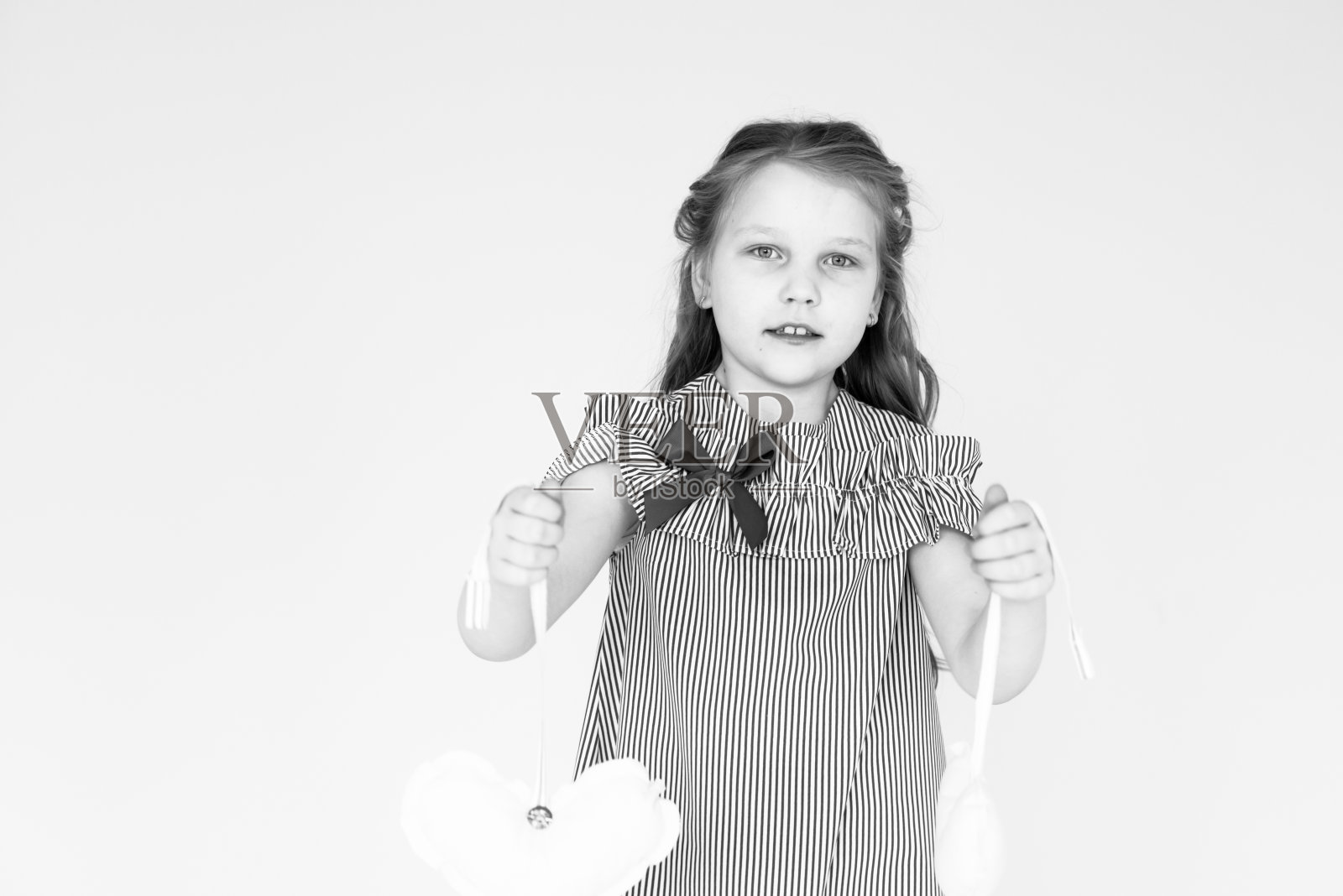 一张黑白照片，一个女孩抱着毛绒玩具。照片摄影图片