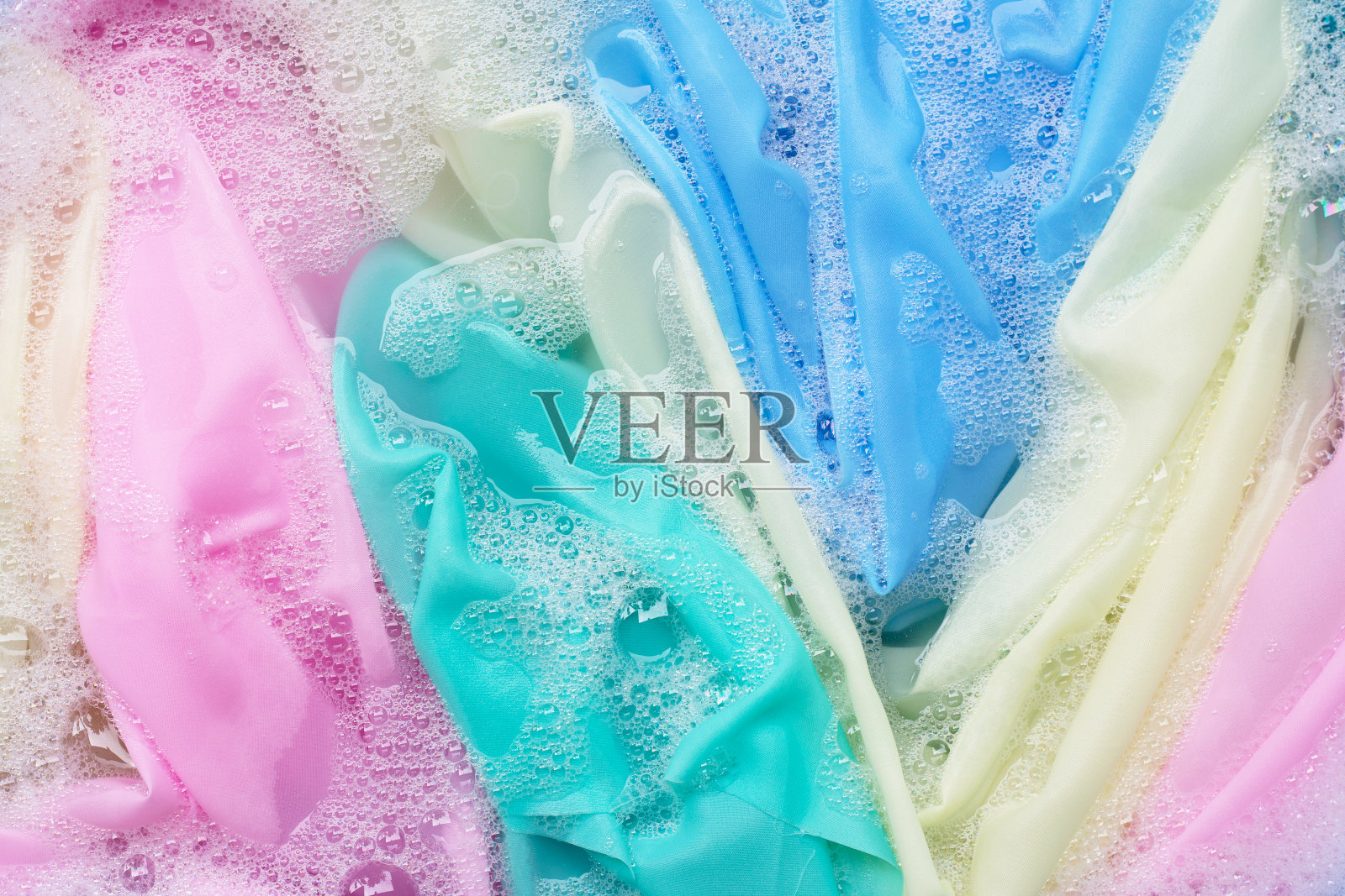 颜色衣服浸泡在洗衣粉水溶解。衣服的概念照片摄影图片