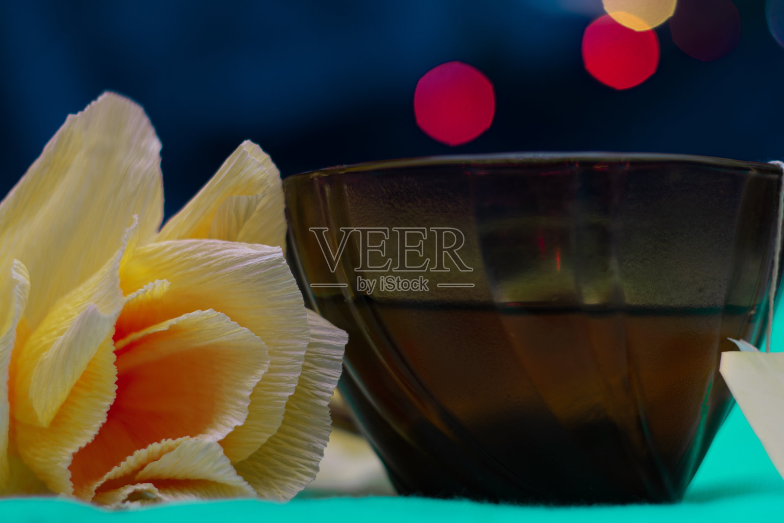 有花香的茶。棕色杯子，黄色花朵，蓝色背景。照片摄影图片