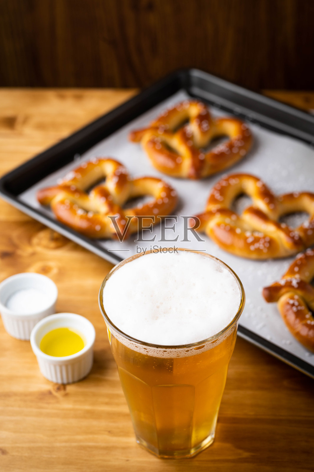 烤椒盐卷饼在烹饪锅和啤酒照片摄影图片