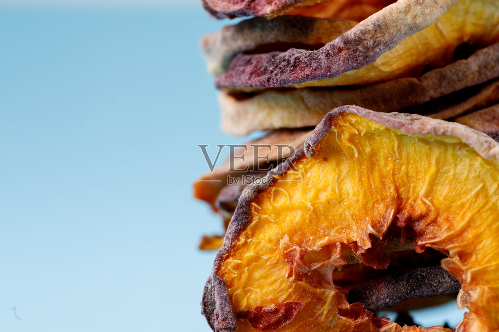 蓝色背景上的几片干桃。干果。生态。照片摄影图片