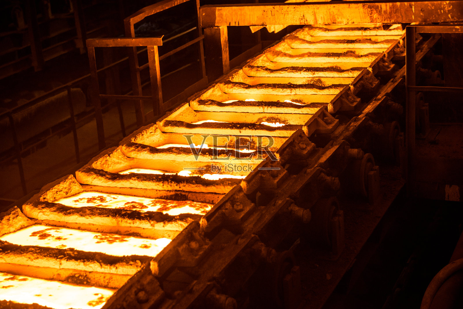 炼钢厂输送带上的模具中的液态金属照片摄影图片