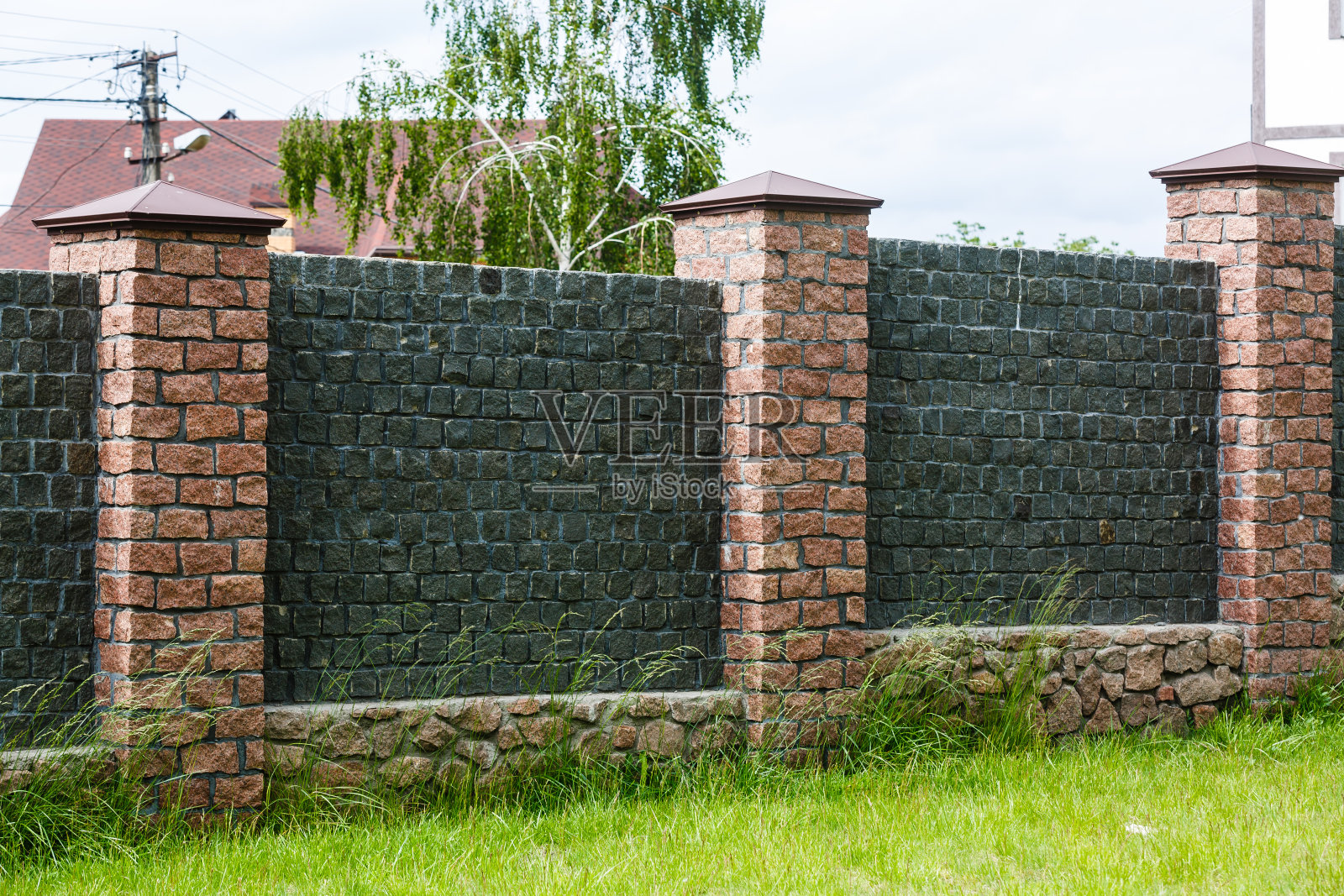 有草坪的砖篱笆的一部分。照片摄影图片