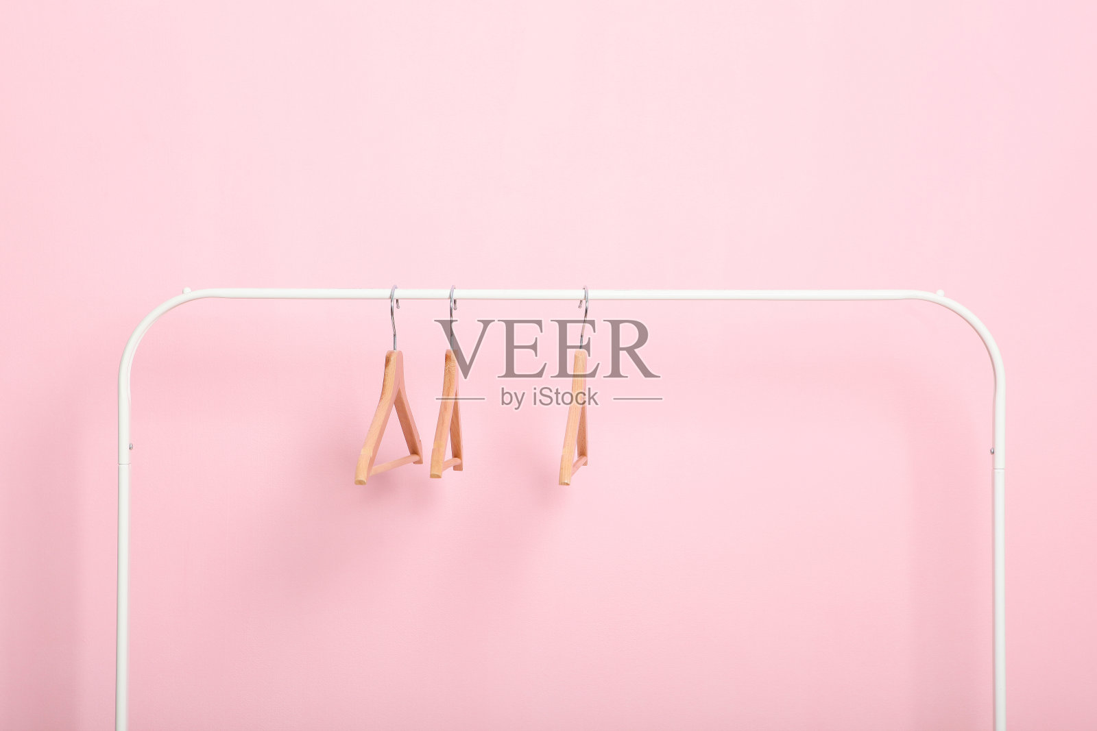 在彩色背景上，空的衣架放在衣柜的架子上。照片摄影图片