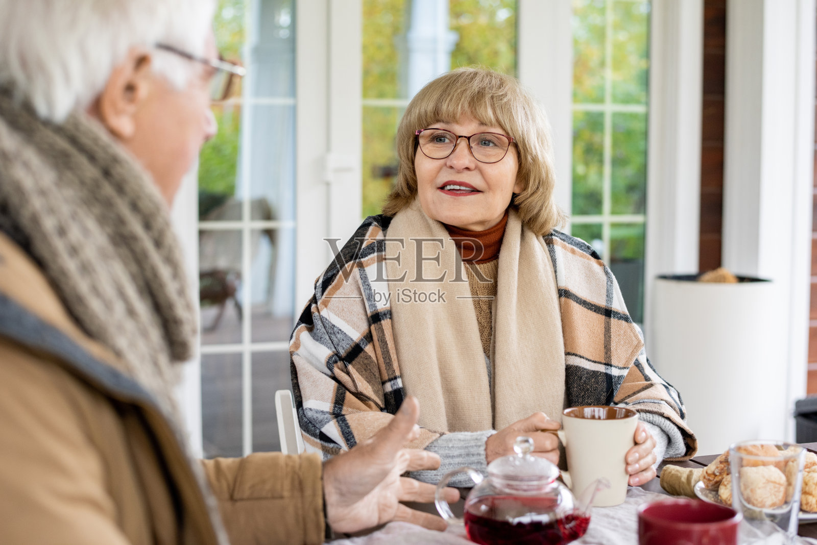 快乐成熟的女性戴着眼镜和温暖的休闲装看着她的丈夫照片摄影图片