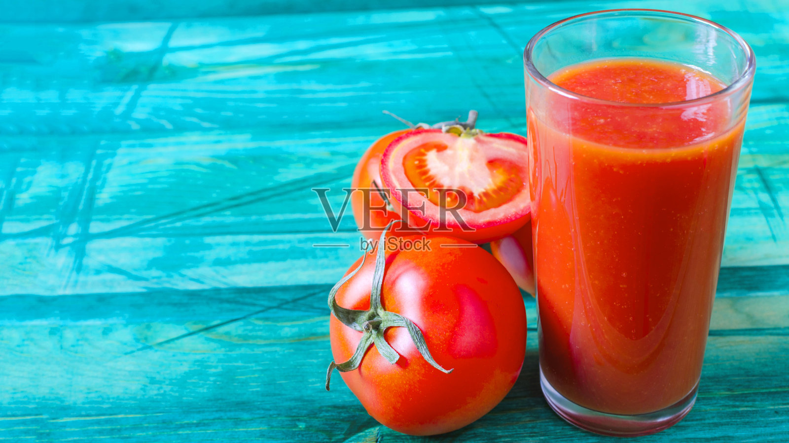 番茄汁在一个透明的玻璃和西红柿在一个木制背景Kopi空间照片摄影图片