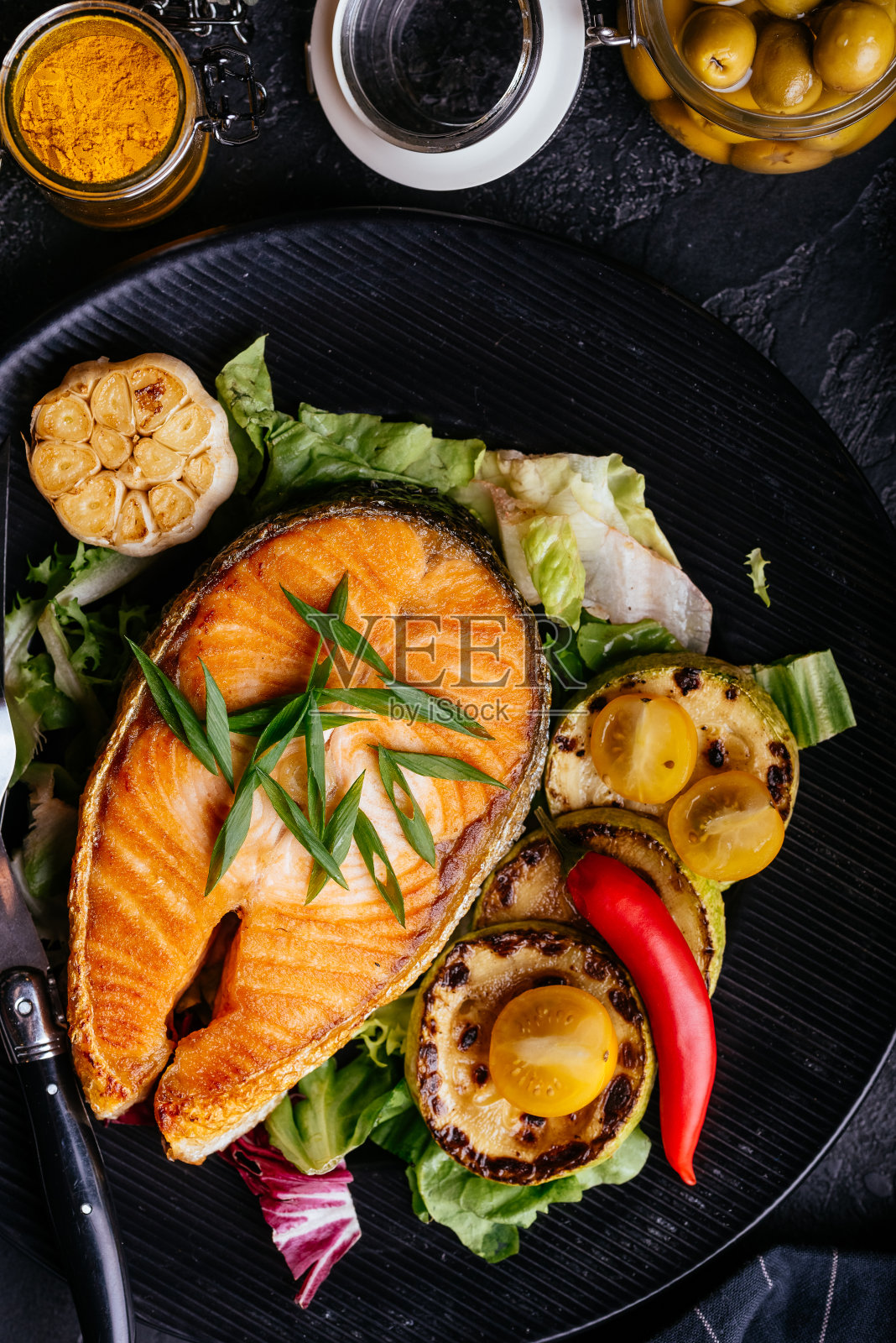 鲑鱼牛排在炭火上烤和蔬菜在黑色的背景照片摄影图片