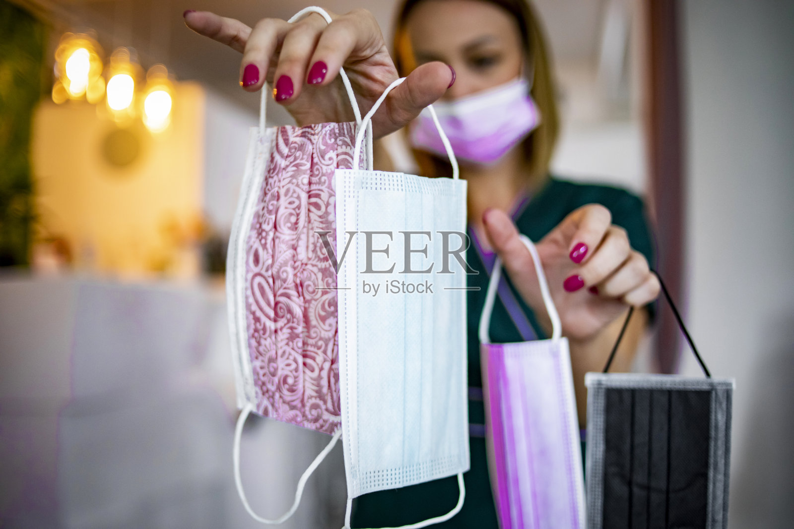 美容师手里拿着各种颜色的防护口罩照片摄影图片