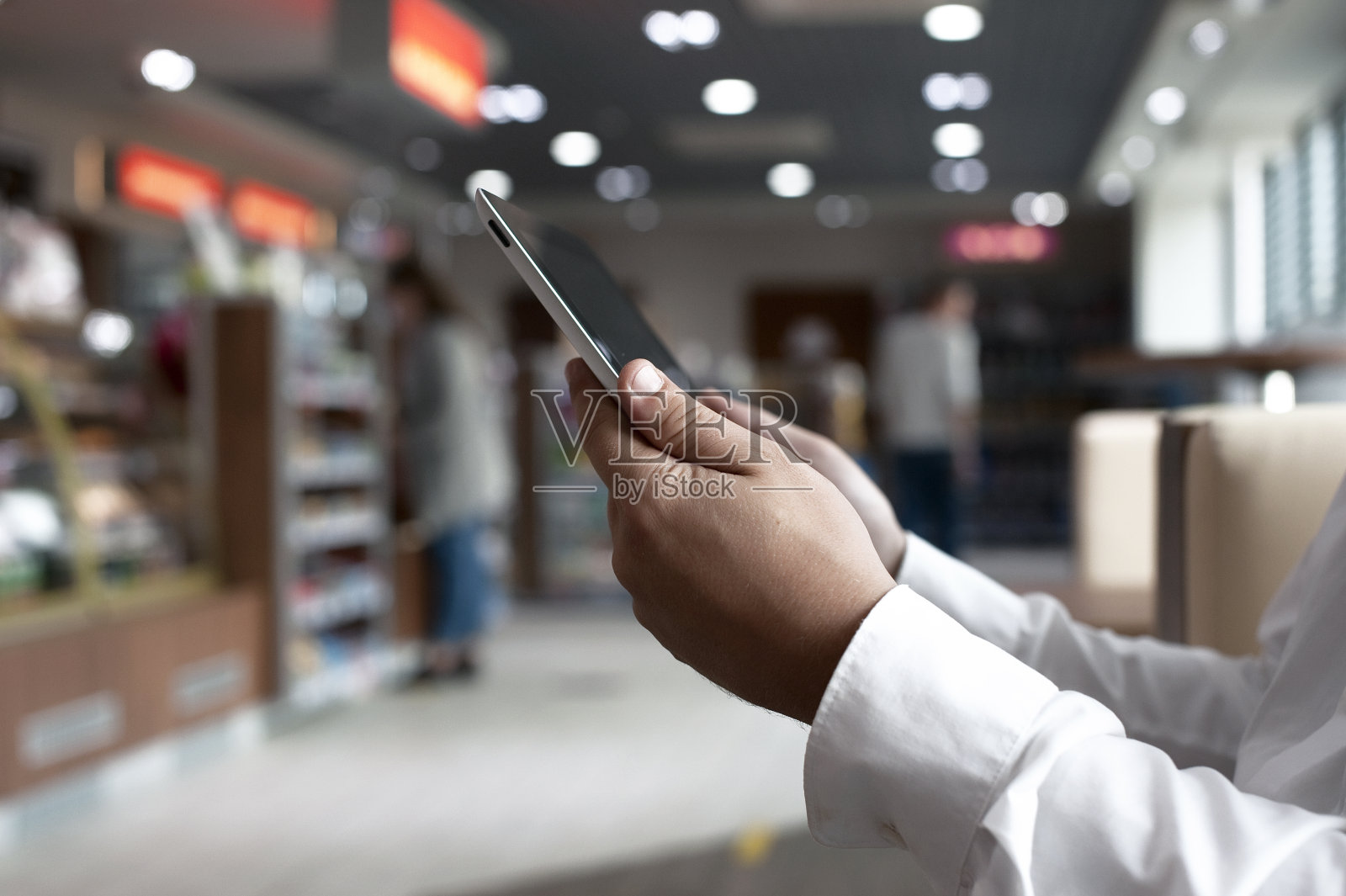 穿着白衬衫的自由商人，手里拿着数码平板电脑。照片摄影图片