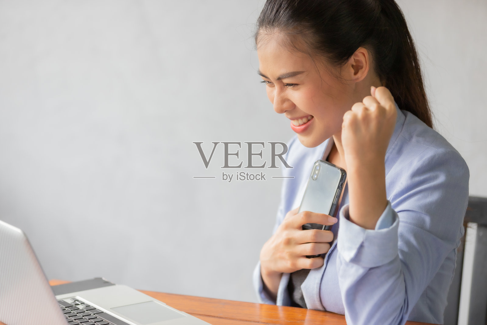 职场女性看手机后感觉成功照片摄影图片