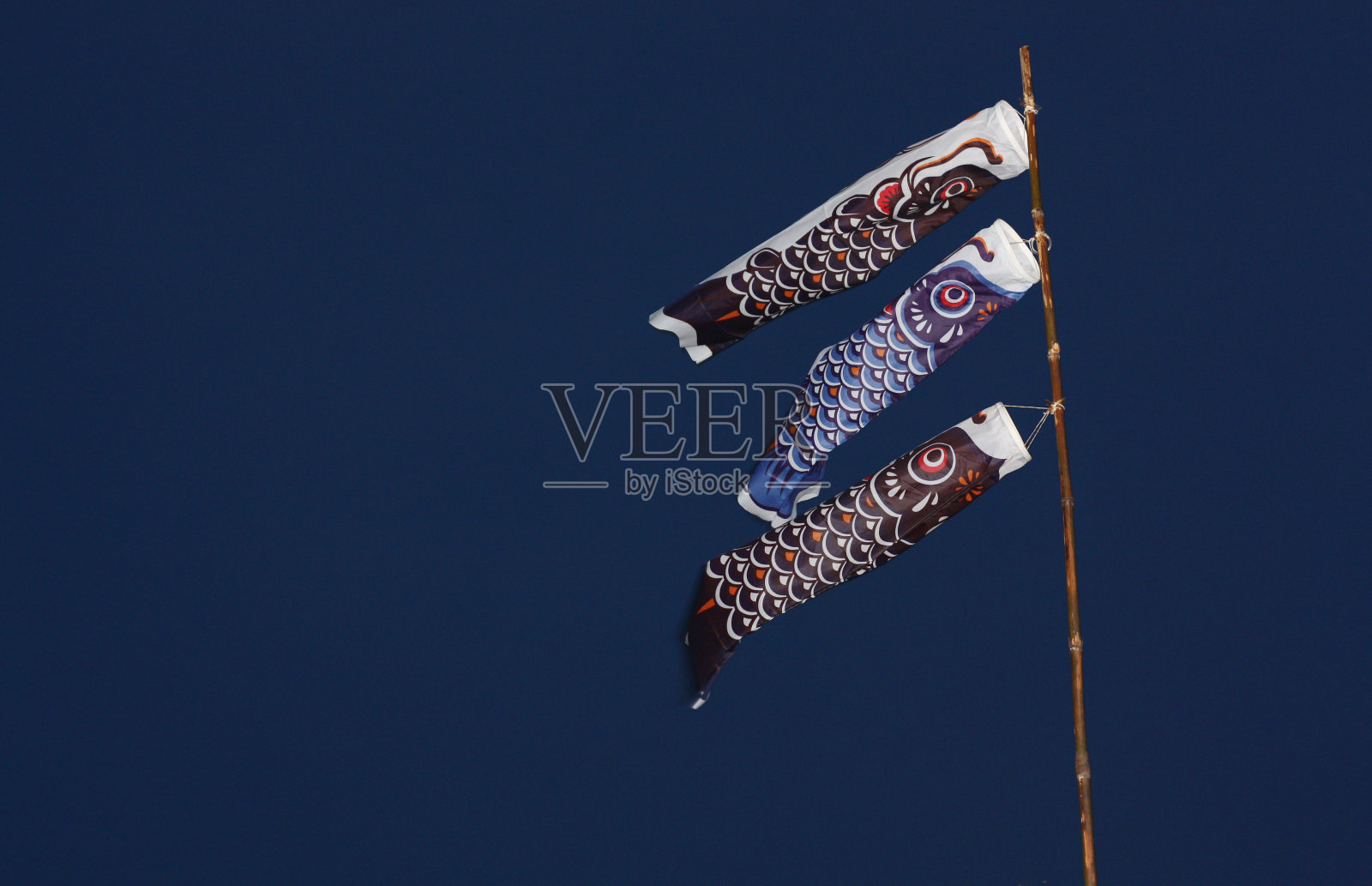 象征花哨的垃圾风筝与风在蓝色的背景照片摄影图片