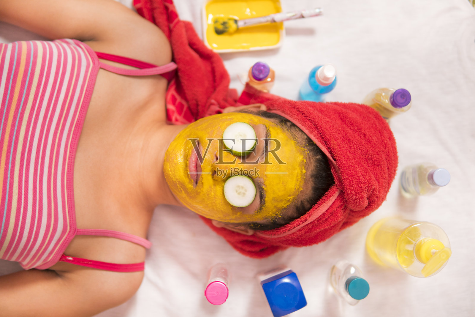 女人用黄瓜片敷在眼睛上放松自己。照片摄影图片